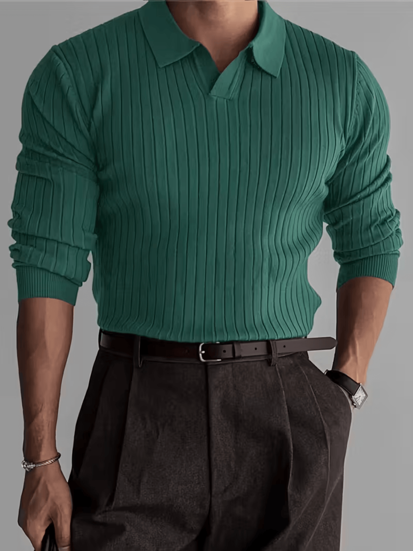 Groene ribgebreide polo trui met lange mouwen voor heren, gecombineerd met donkere pantalon en leren riem.